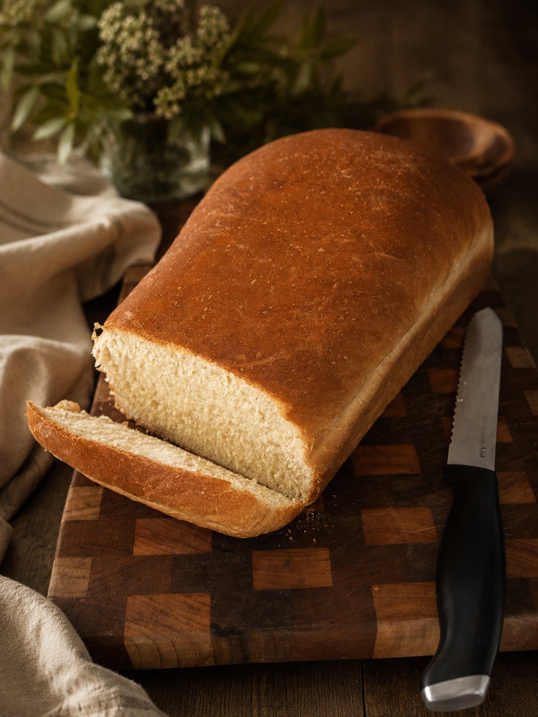 Freshly baked loaf of bread sliced on a wooden board